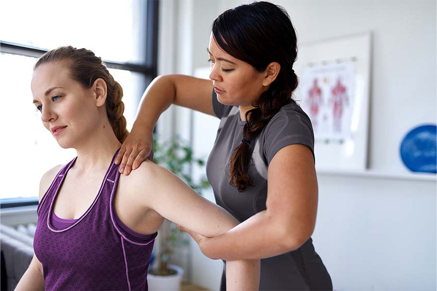 Physiotherapist helping a woman with arm pain